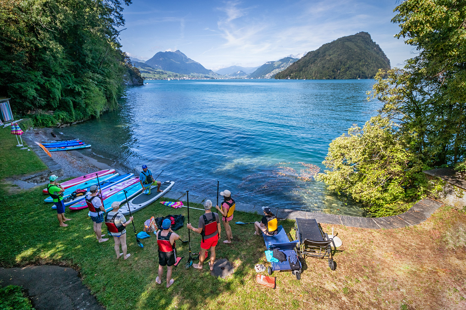 Personen mit Booten an einem See